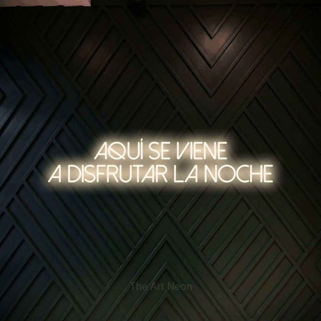 LED neon sign reading “Aquí se viene a disfrutar la noche”, arranged in 2 lines.