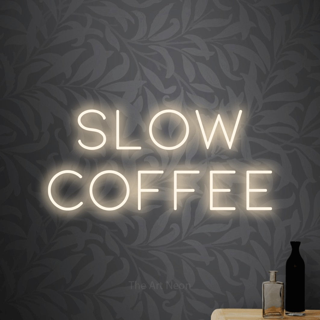 LED neon sign reading “slow coffee”, arranged in 2 lines.