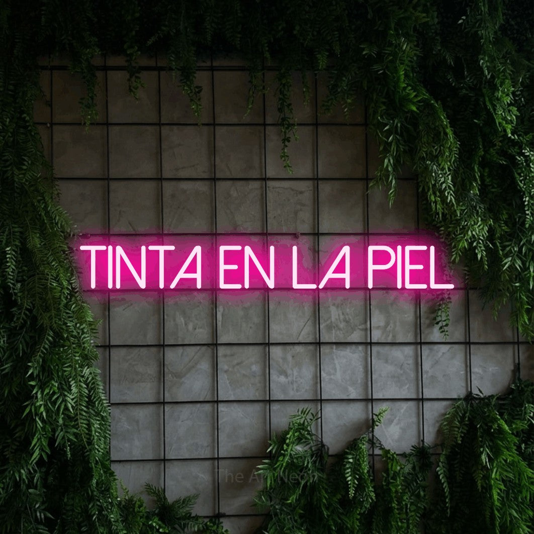 LED neon sign reading “tinta en la piel”, arranged in a single line.