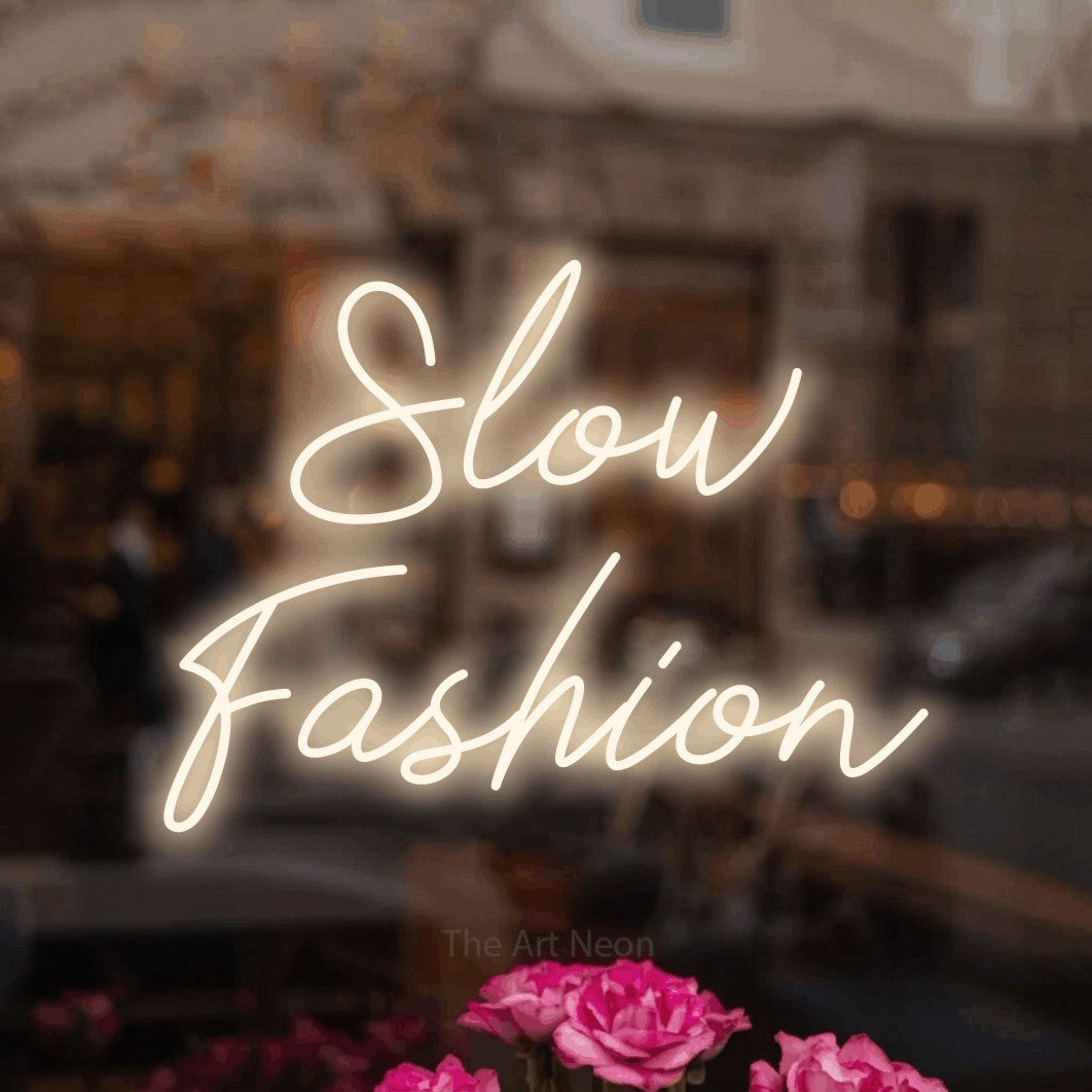 LED neon sign reading “Slow Fashion”, arranged in 2 lines.