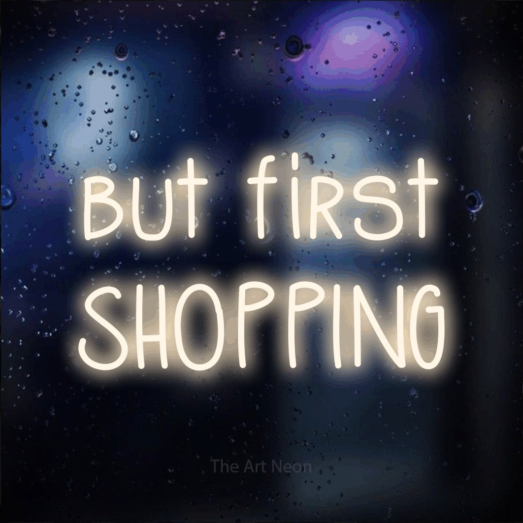 LED neon sign reading “but first SHOPPING”, arranged in 2 lines.