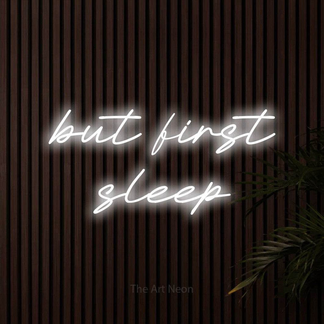 LED neon sign reading “but first sleep”, arranged in 2 lines.