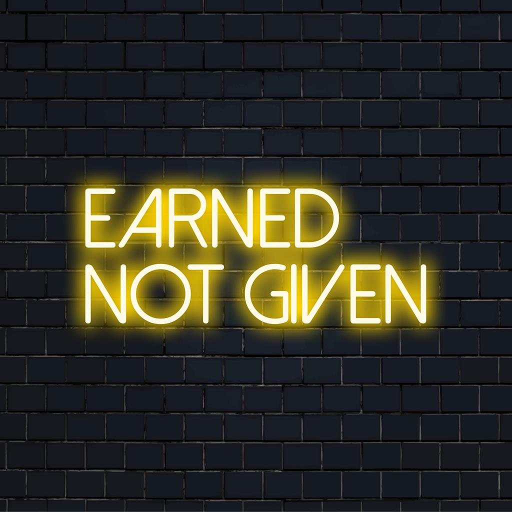 Custom LED neon sign from The Art Neon brand, featuring the inspiring phrase Earned Not Given in vibrant, glowing letters.