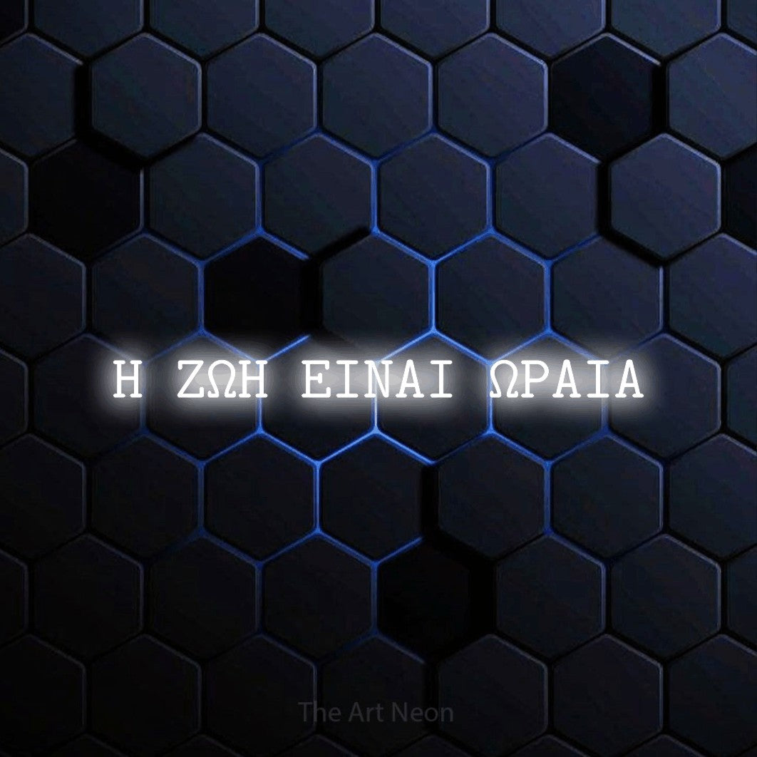 LED neon sign reading “Η ΖΩΗ ΕΙΝΑΙ ΩΡΑΙΑ”, arranged in a single line.