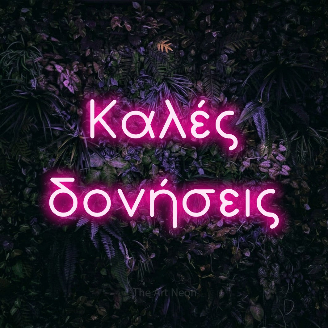 LED neon sign reading “Καλές δονήσεις”, arranged in two lines.