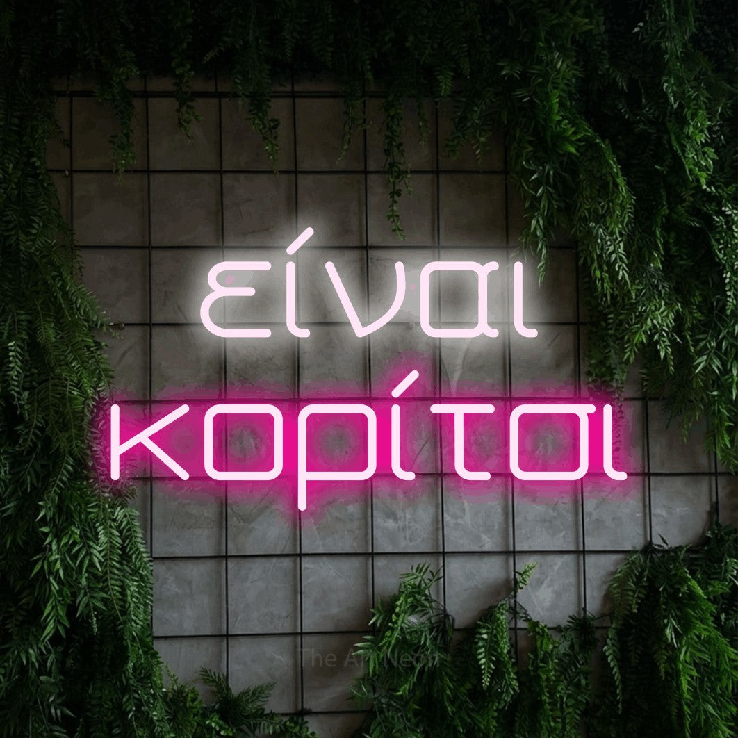LED neon sign reading “είναι κορίτσι”, arranged in two lines.