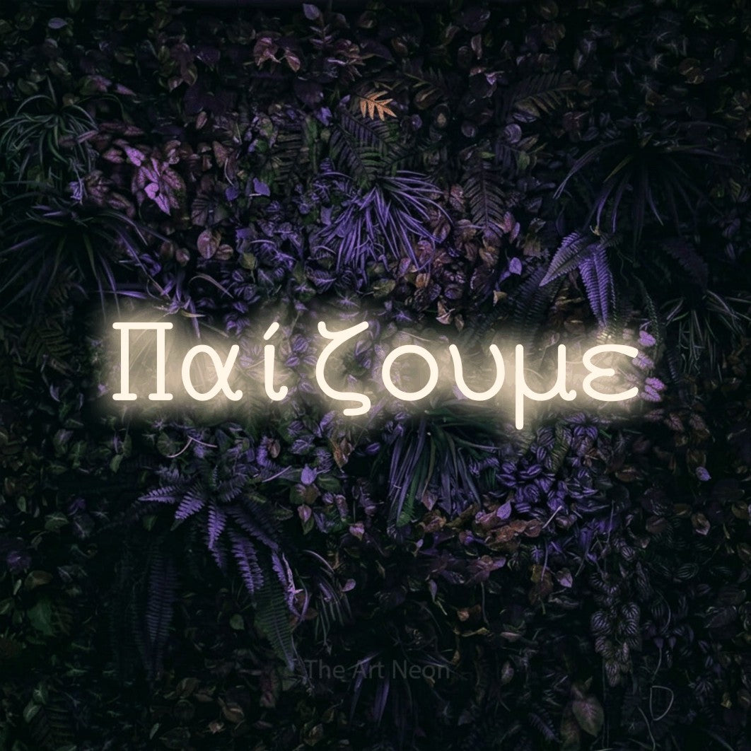 LED neon sign reading “Παίζουμε”, arranged in a single line.
