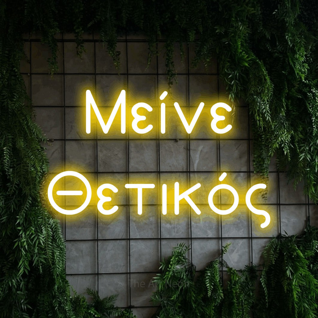 LED neon sign reading “Μείνε Θετικός”, arranged in two lines.