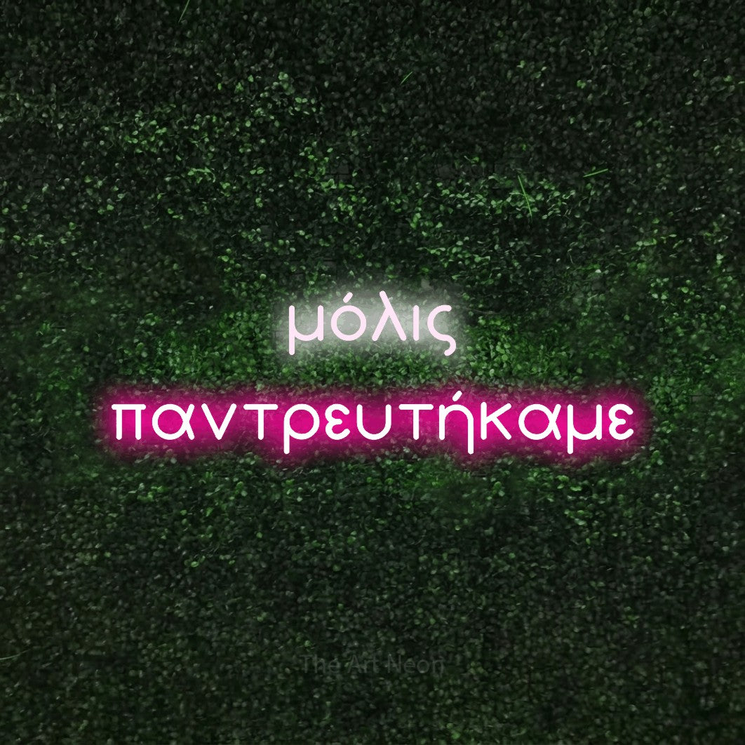 LED neon sign reading “μόλις παντρευτήκαμε”, arranged in two lines.