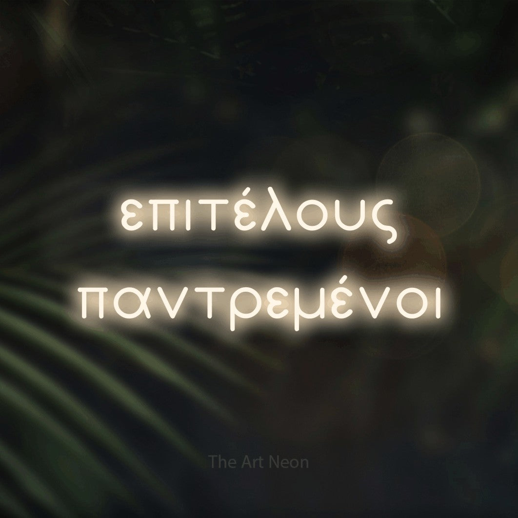 LED neon sign reading “επιτέλους παντρεμένοι”, arranged in two lines.
