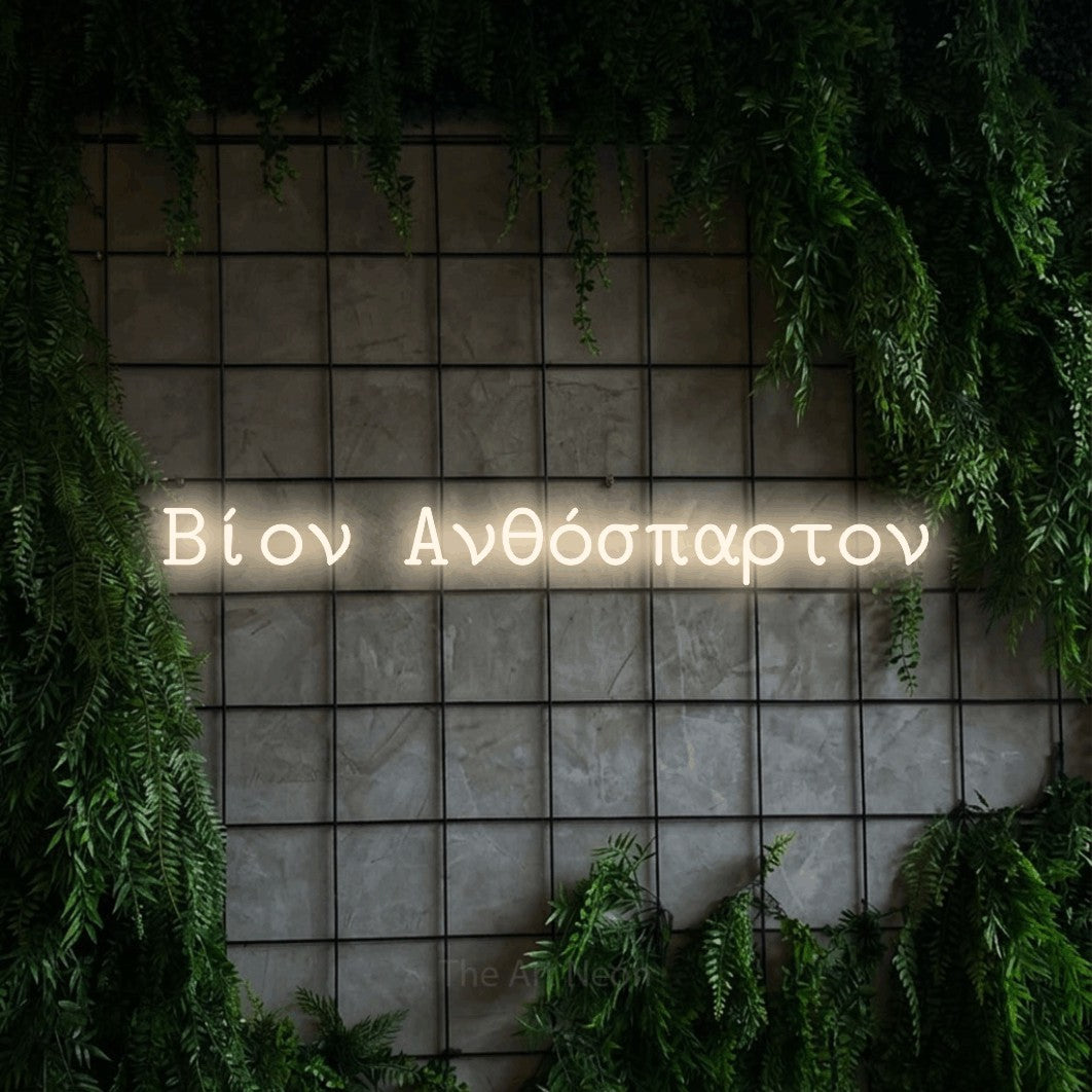 LED neon sign reading “Βίον Ανθόσπαρτον”, arranged in a single line.