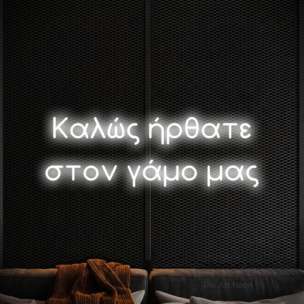 LED neon sign reading “Καλώς ήρθατε στον γάμο μας”, arranged in two lines.