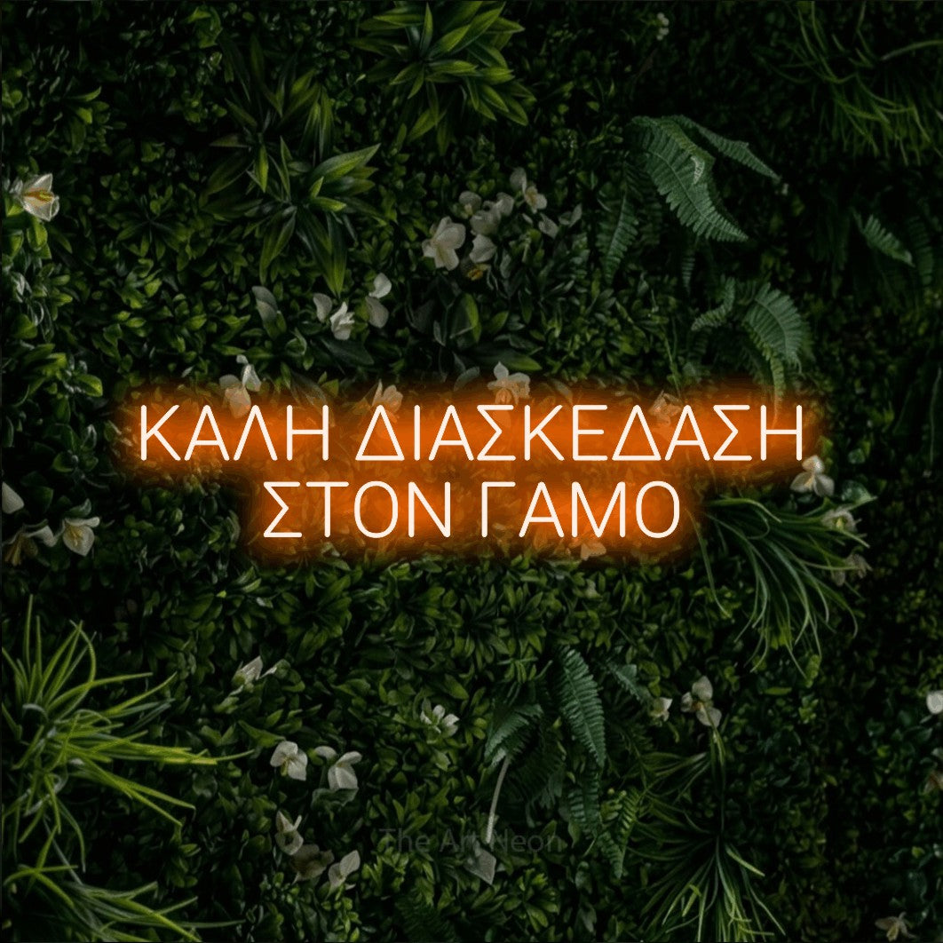 LED neon sign reading “ΚΑΛΗ ΔΙΑΣΚΕΔΑΣΗ ΣΤΟΝ ΓΑΜΟ”, arranged in two lines.
