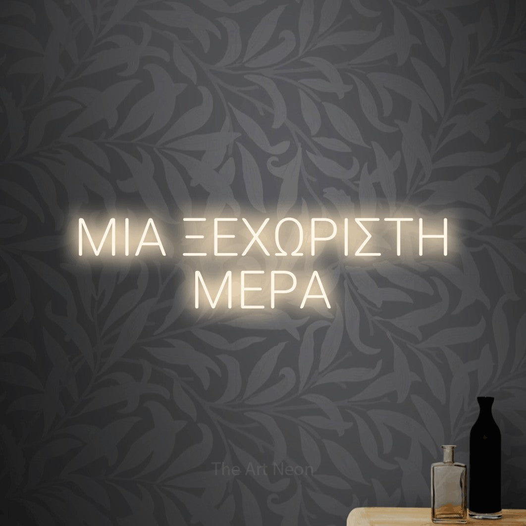 LED neon sign reading “ΜΙΑ ΞΕΧΩΡΙΣΤΗ ΜΕΡΑ”, arranged in two lines.