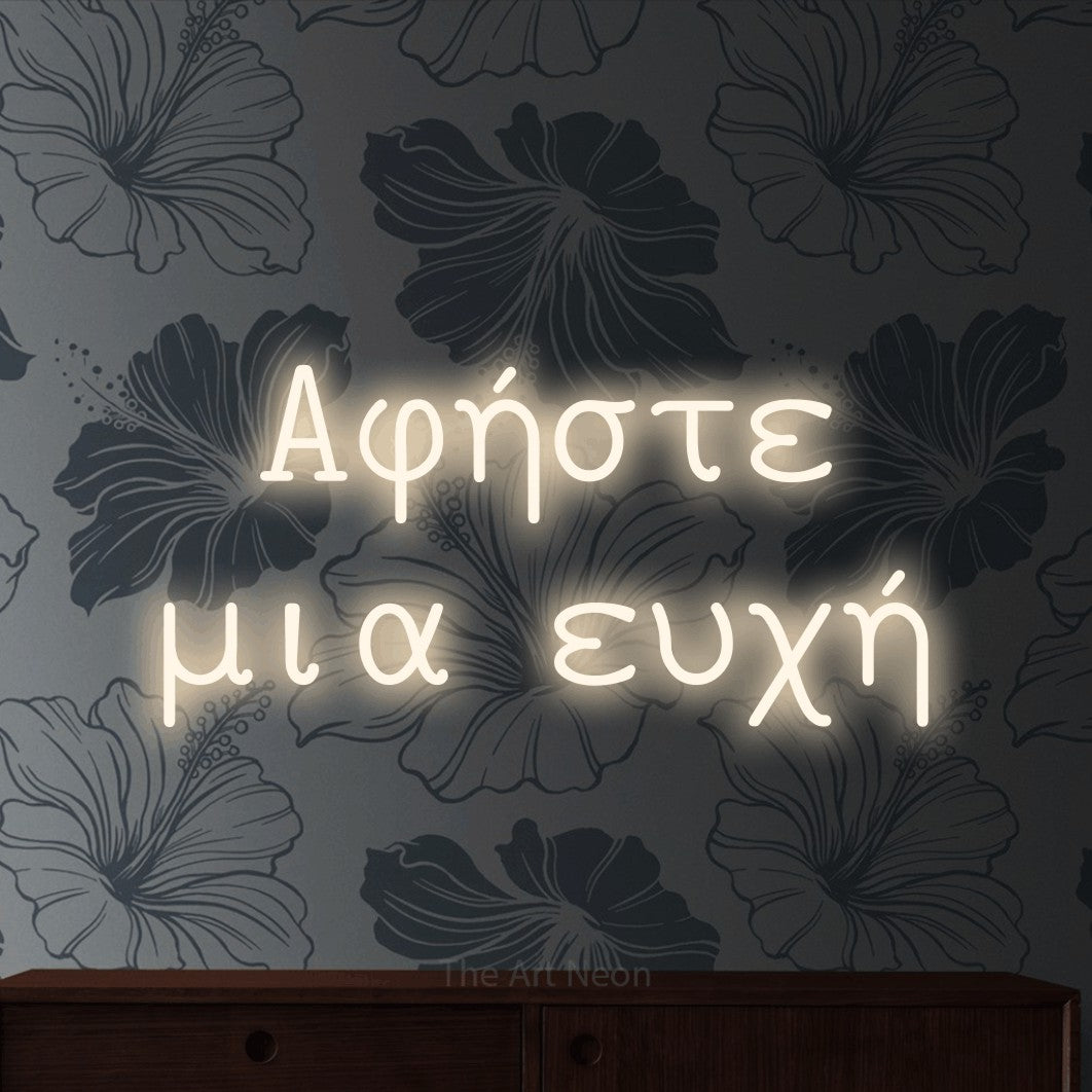 LED neon sign reading “Αφήστε μια ευχή”, arranged in two lines.