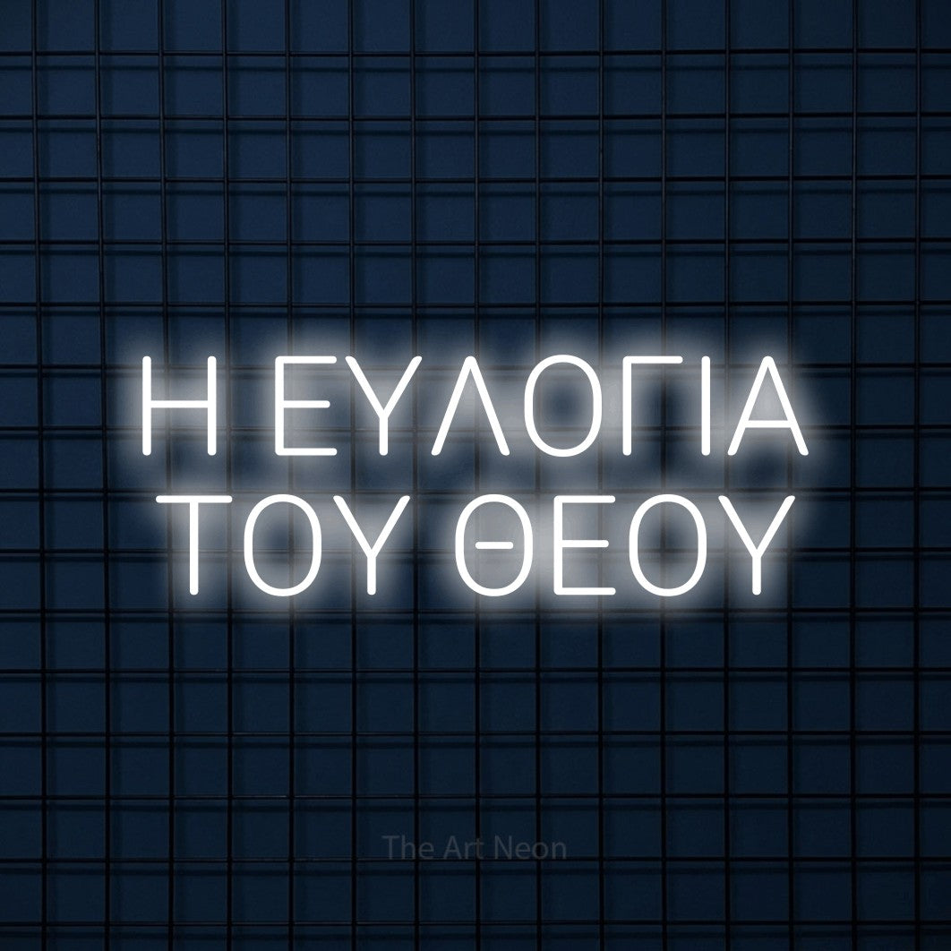 LED neon sign reading “Η ΕΥΛΟΓΙΑ ΤΟΥ ΘΕΟΥ”, arranged in two lines.