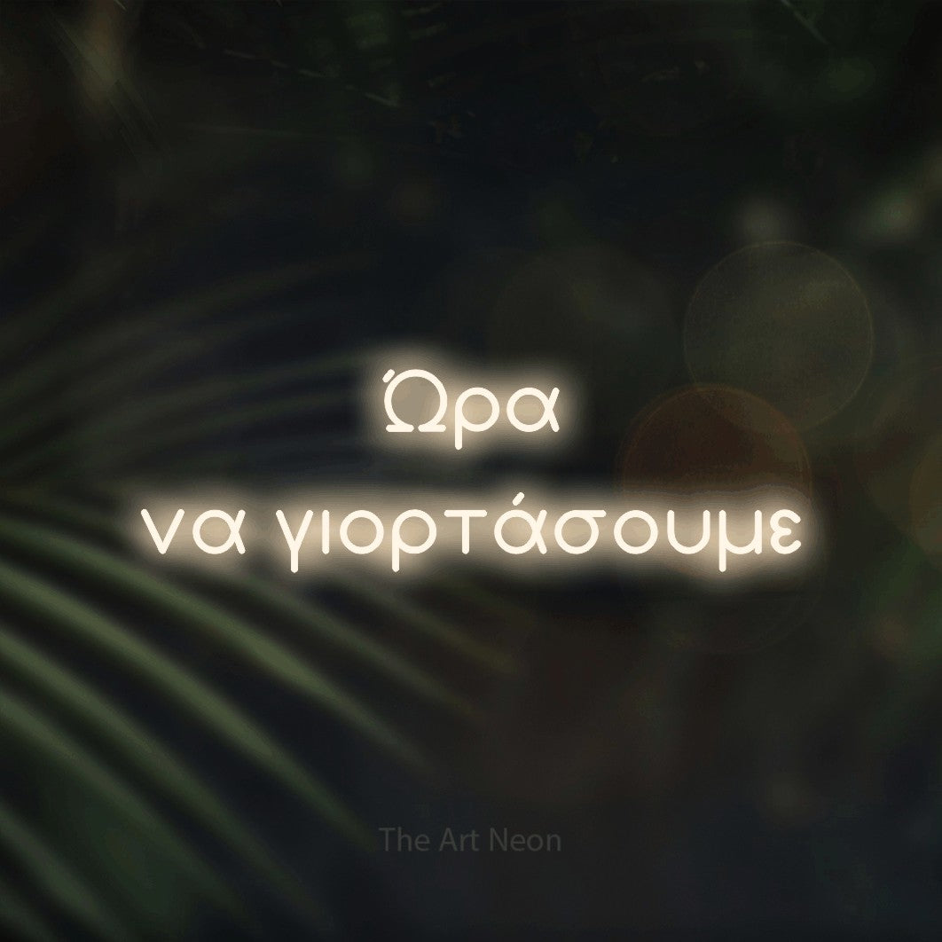 LED neon sign reading “Ώρα να γιορτάσουμε”, arranged in two lines.