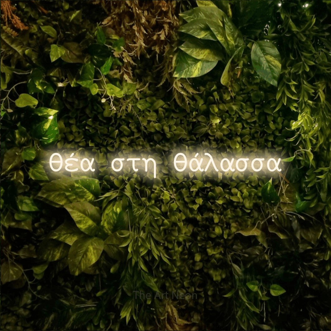 LED neon sign reading “θέα στη θάλασσα”, arranged in a single line.