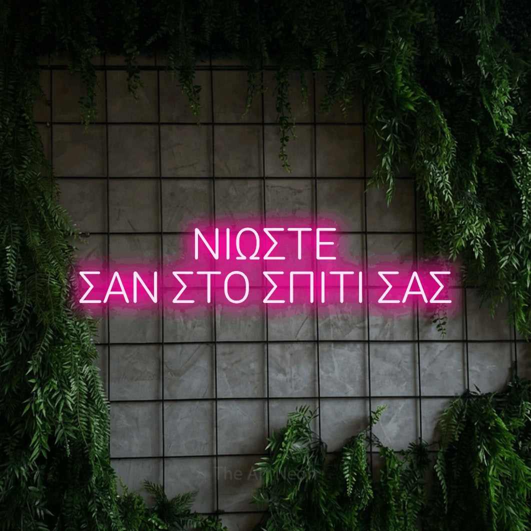 LED neon sign reading “ΝΙΩΣΤΕ ΣΑΝ ΣΤΟ ΣΠΙΤΙ ΣΑΣ”, arranged in two lines.
