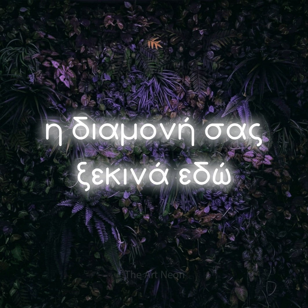 LED neon sign reading “η διαμονή σας ξεκινά εδώ”, arranged in two lines.