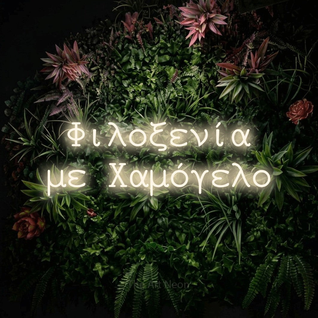 LED neon sign reading “Φιλοξενία με Χαμόγελο”, arranged in two lines.
