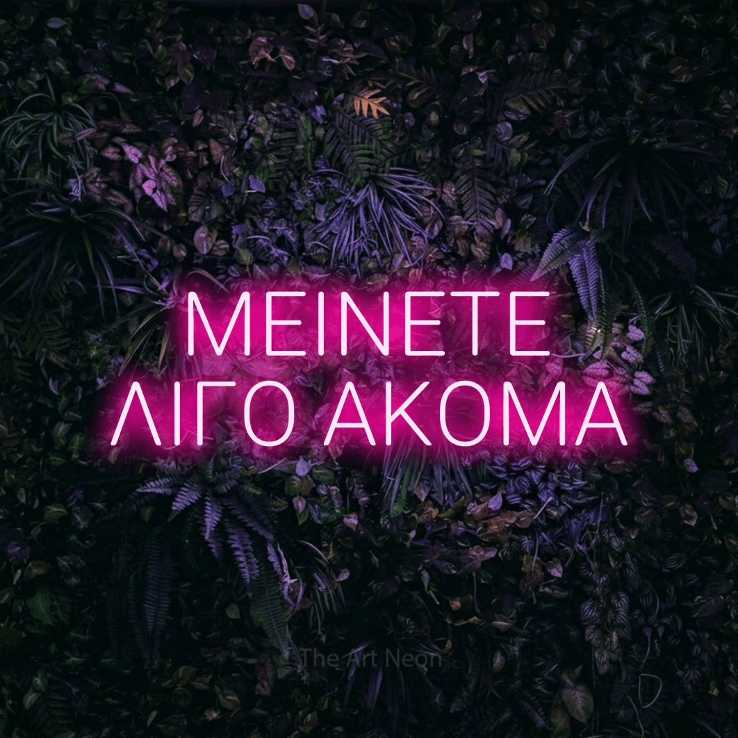 LED neon sign reading “ΜΕΙΝΕΤΕ ΛΙΓΟ ΑΚΟΜΑ”, arranged in two lines.