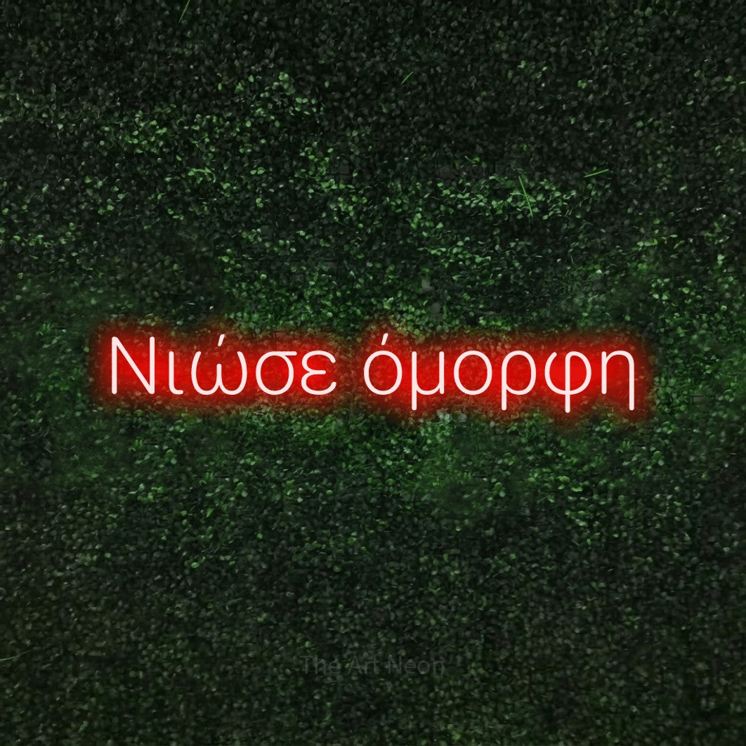 LED neon sign reading “Νιώσε όμορφη”, arranged in a single line.
