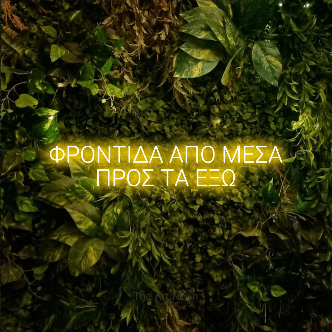 LED neon sign reading “ΦΡΟΝΤΙΔΑ ΑΠΟ ΜΕΣΑ ΠΡΟΣ ΤΑ ΕΞΩ”, arranged in two lines.