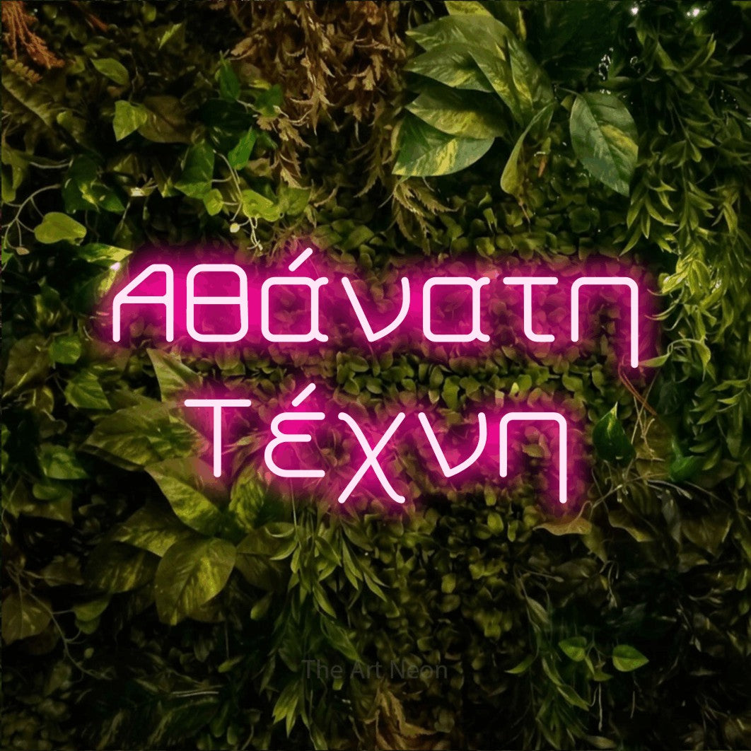 LED neon sign reading “Αθάνατη Τέχνη”, arranged in two lines.