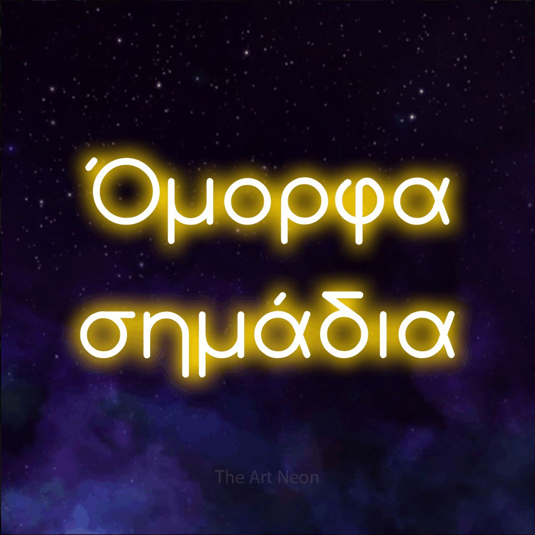 LED neon sign reading “Όμορφα σημάδια”, arranged in two lines.