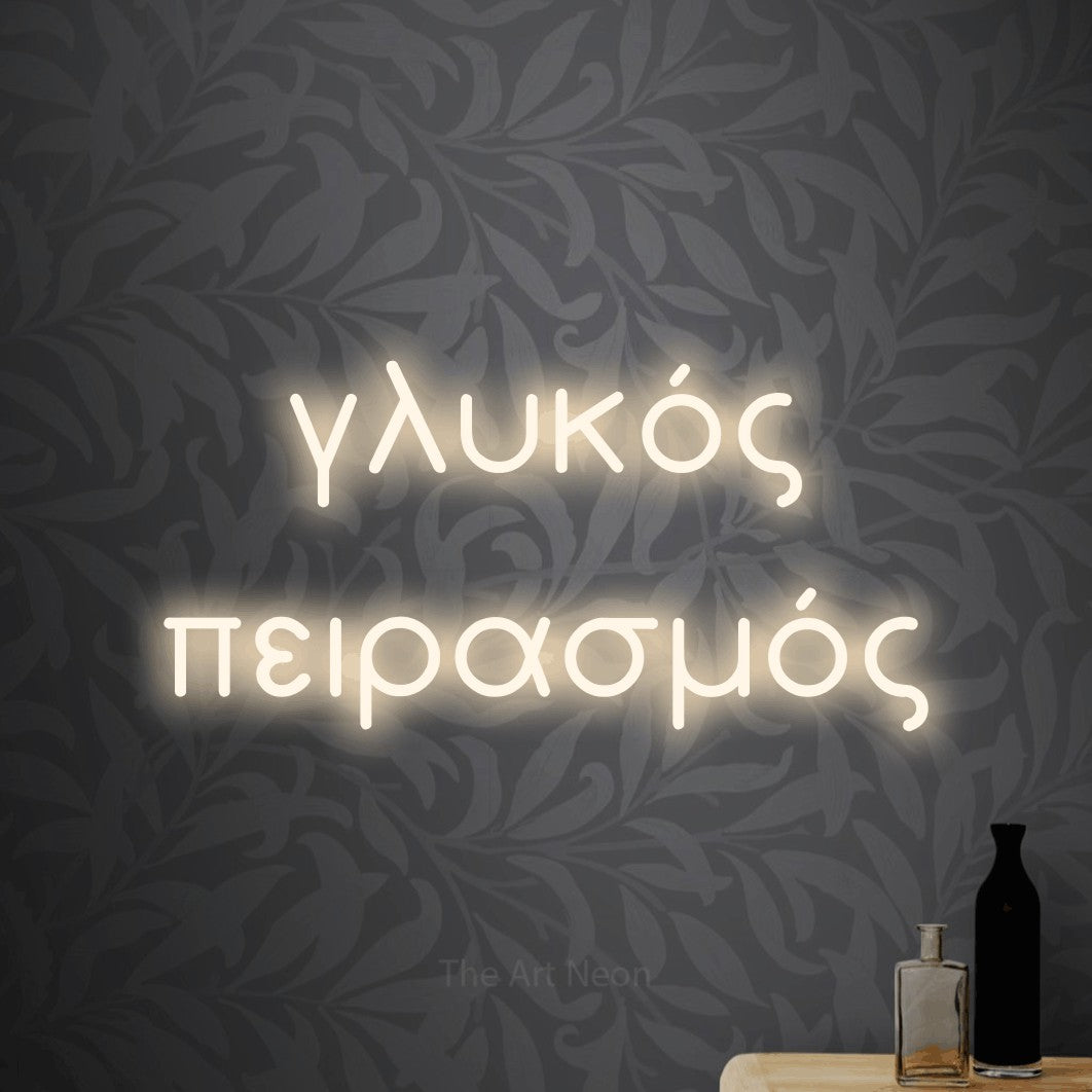 LED neon sign reading “γλυκός πειρασμός”, arranged in two lines.