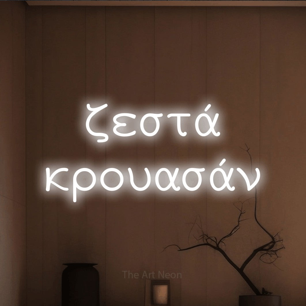 LED neon sign reading “ζεστά κρουασάν”, arranged in two lines.
