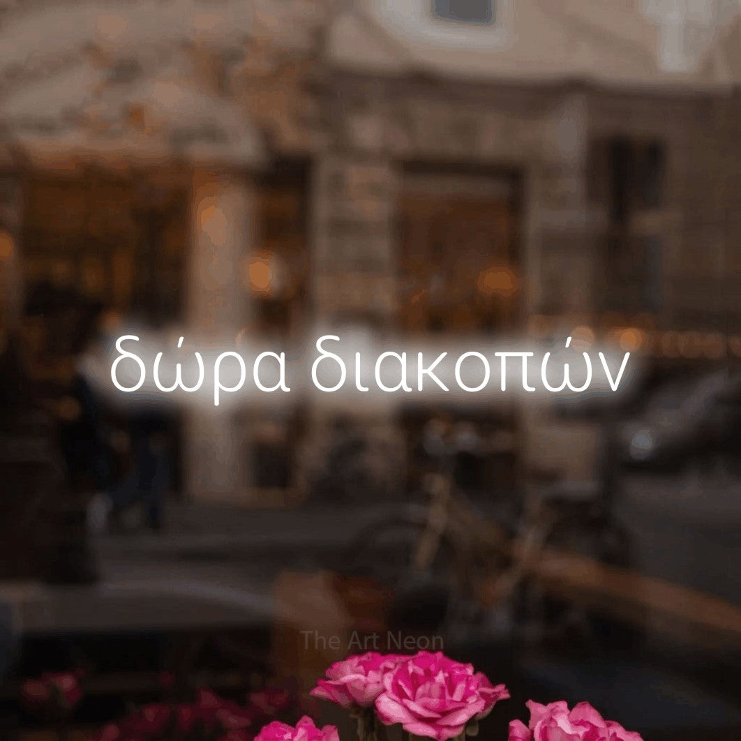 LED neon sign reading “δώρα διακοπών”, arranged in a single line.