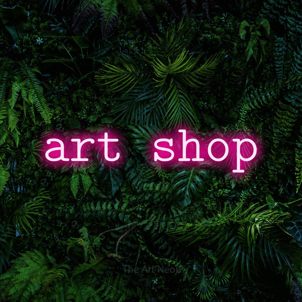 LED neon sign reading “art shop”, arranged in a single line.