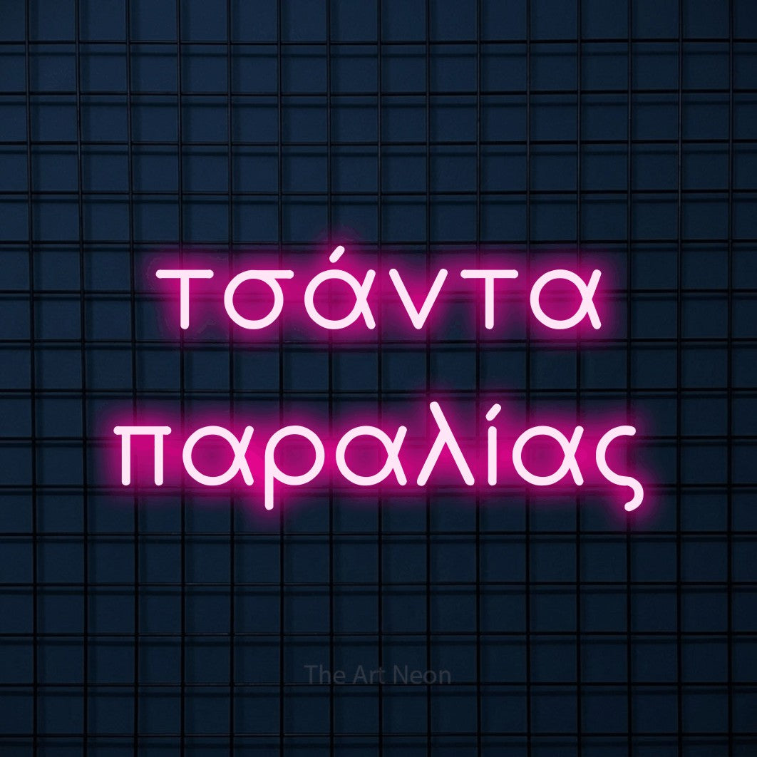 LED neon sign reading “τσάντα παραλίας”, arranged in two lines.