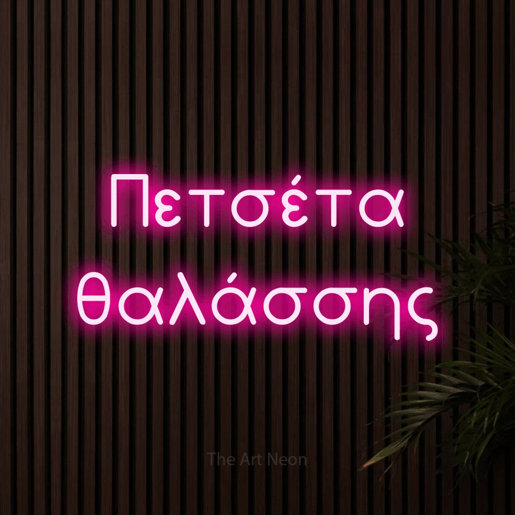 LED neon sign reading “Πετσέτα θαλάσσης”, arranged in two lines.