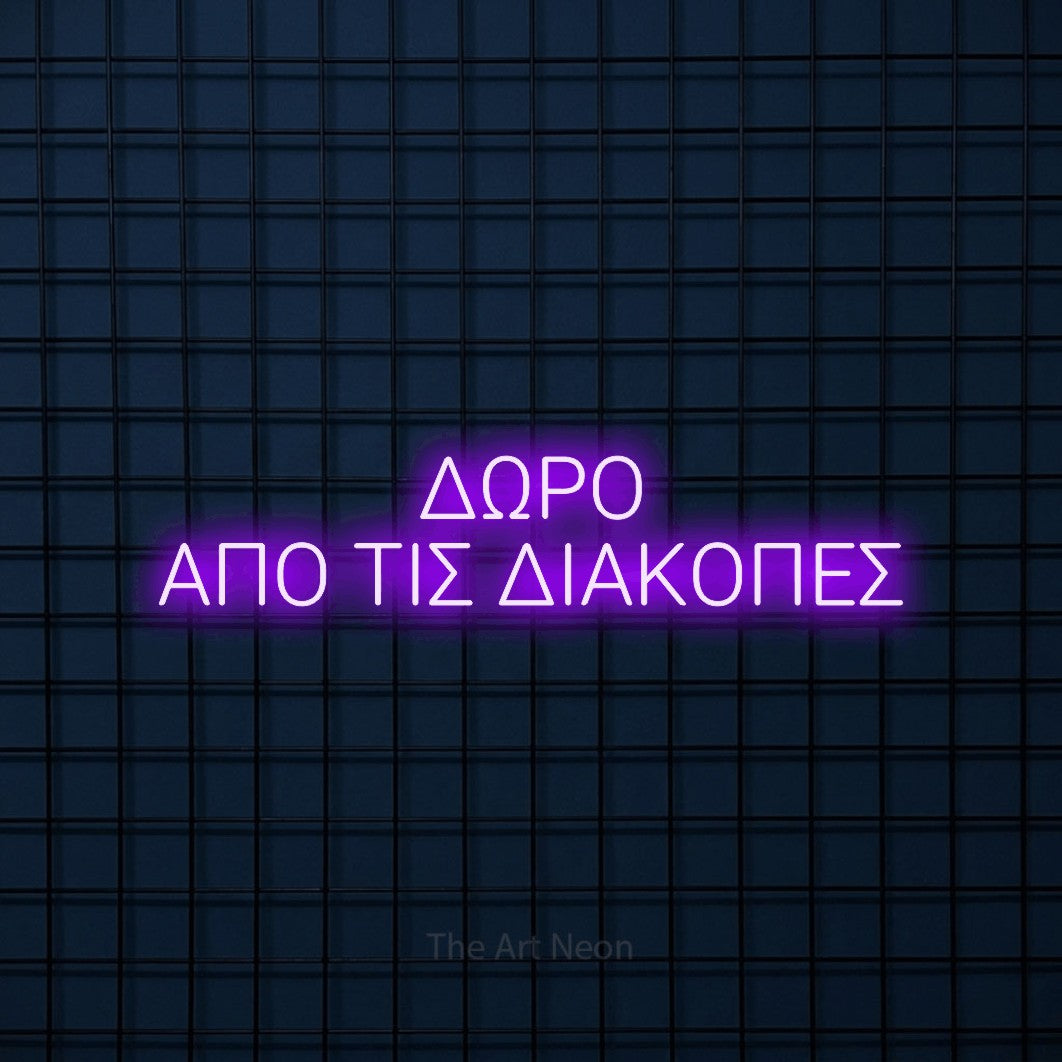 LED neon sign reading “ΔΩΡΟ ΑΠΟ ΤΙΣ ΔΙΑΚΟΠΕΣ”, arranged in two lines.