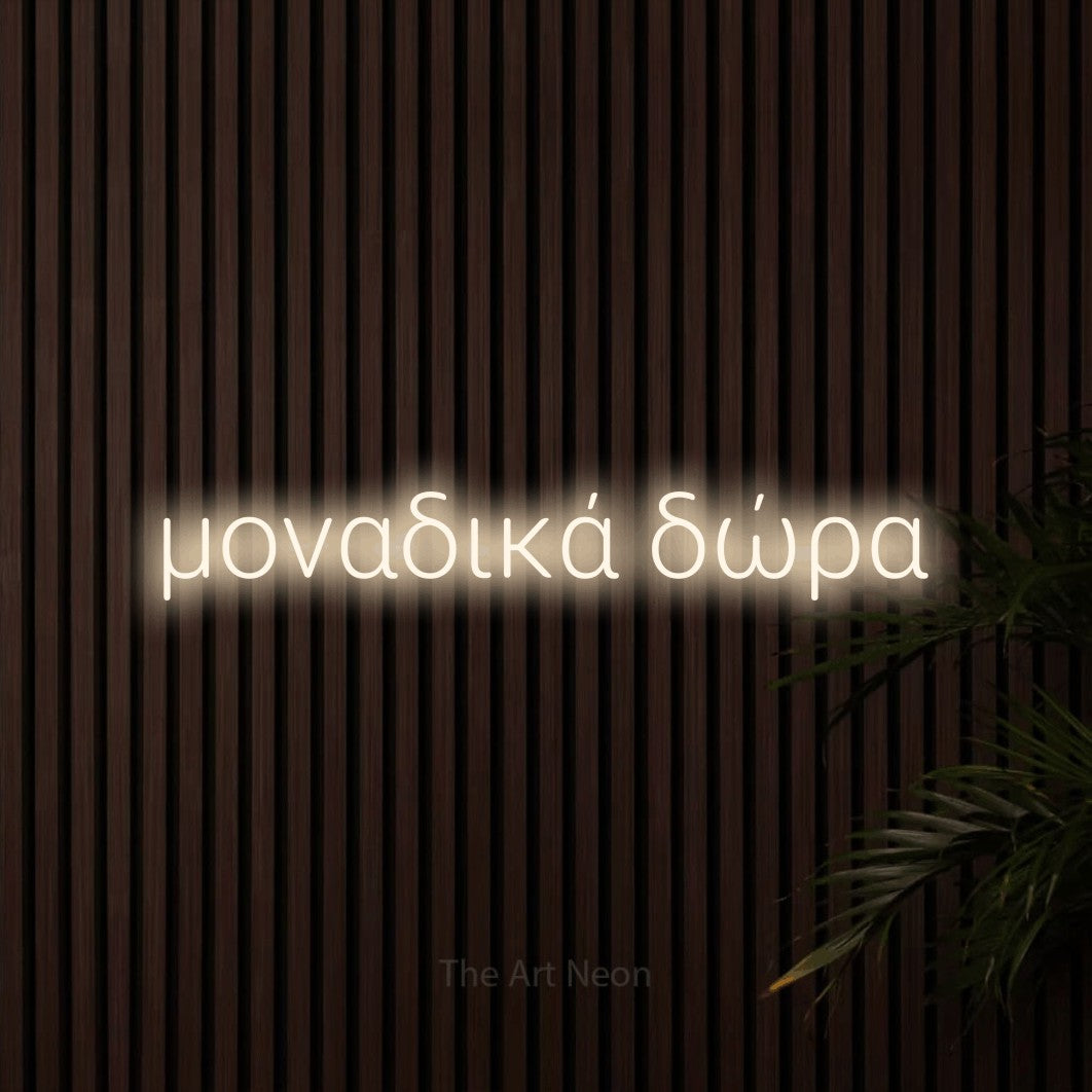 LED neon sign reading “μοναδικά δώρα”, arranged in a single line.