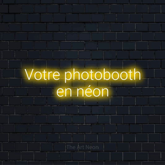 Enseigne néon personnalisée « Votre photobooth en néon » sur un mur en briques noires