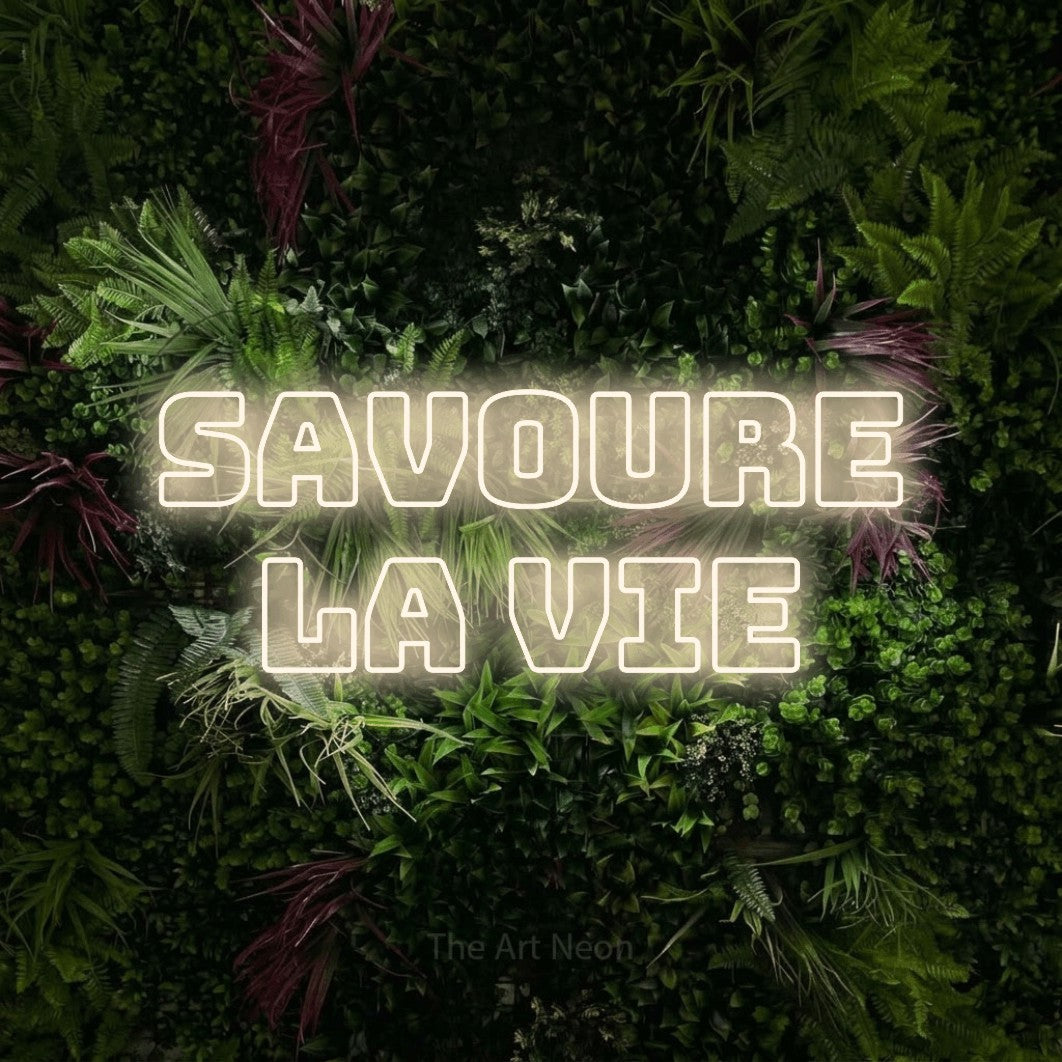 LED neon sign reading “SAVOURE LA VIE”, arranged in 2 lines.