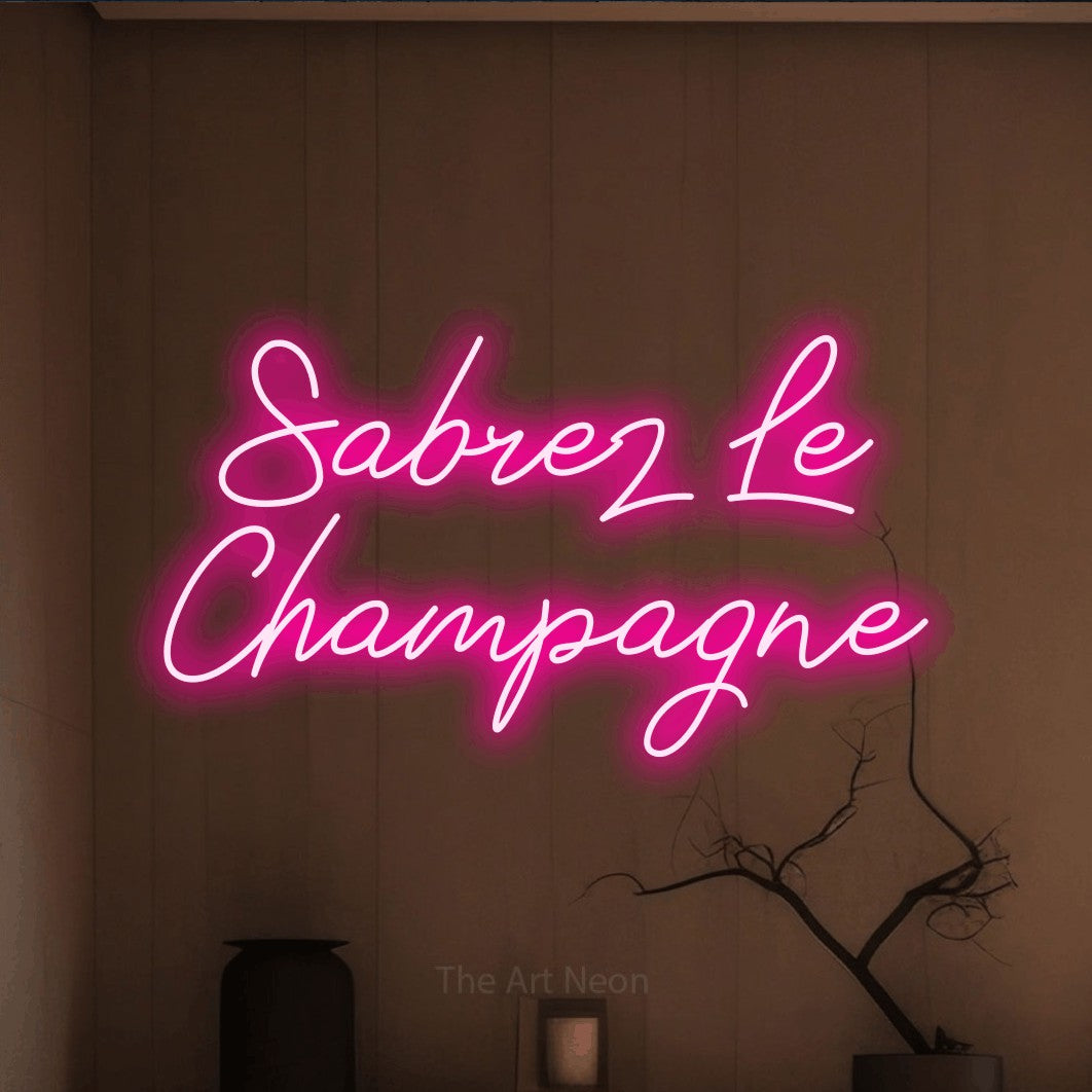 LED neon sign reading “Sabrez Le Champagne”, arranged in 2 lines.