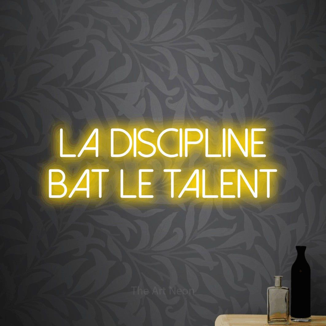 LED neon sign reading “La Discipline Bat Le Talent”, arranged in 2 lines.