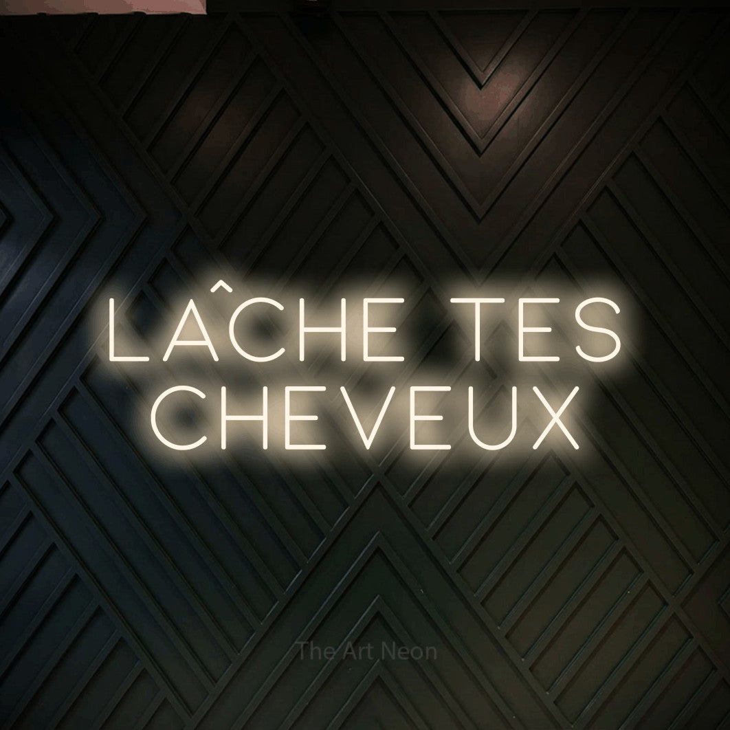 LED neon sign reading “lâche tes CHEVEUX”, arranged in 2 lines.