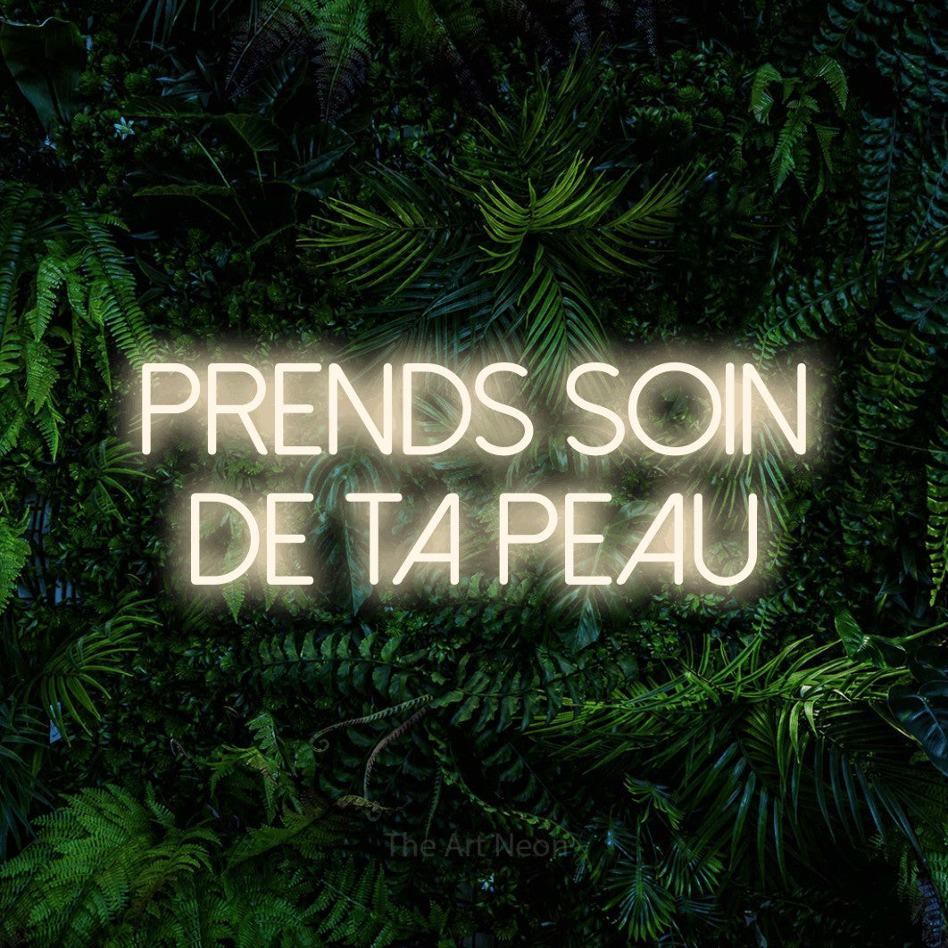 LED neon sign reading “prends soin de ta peau”, arranged in 2 lines.