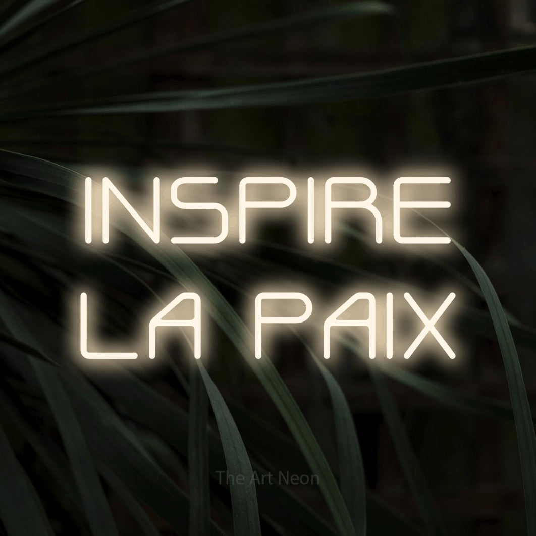 LED neon sign reading “INSPIRE LA PAIX”, arranged in 2 lines.