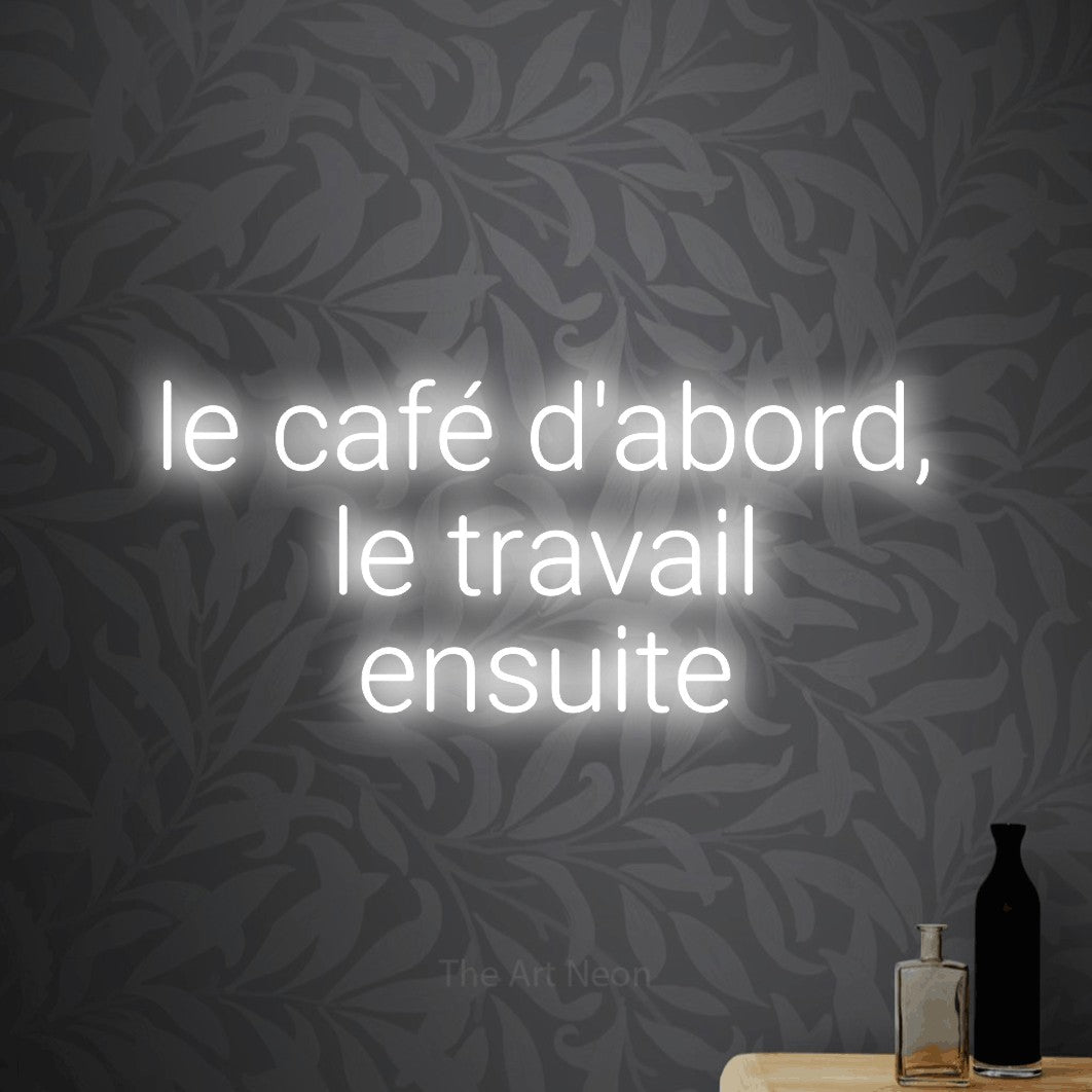 LED neon sign reading “le café d'abord, le travail ensuite”, arranged in 3 lines.