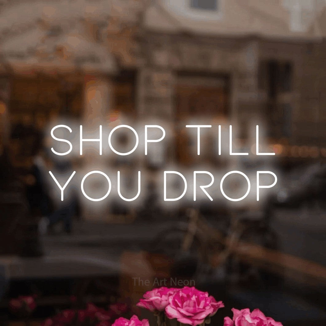 LED neon sign reading “SHOP till you drop”, arranged in 2 lines.