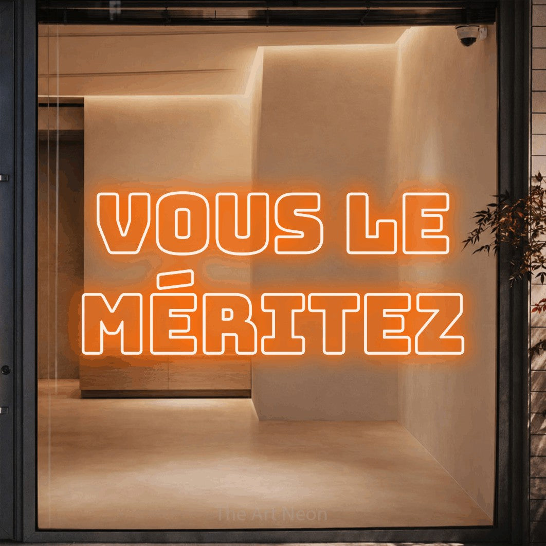 LED neon sign reading “VOUS LE MÉRITEZ”, arranged in 2 lines.