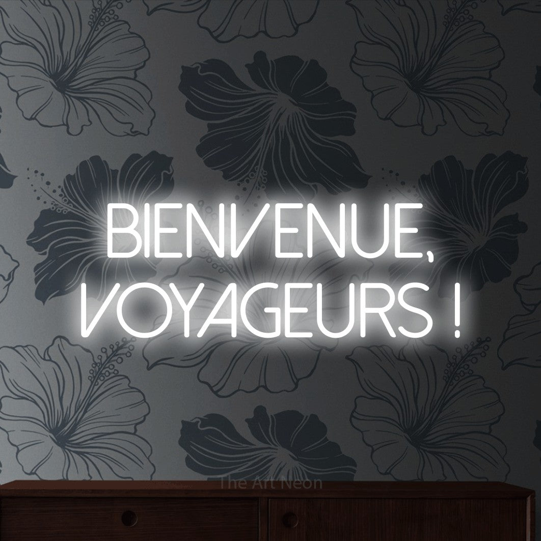 LED neon sign reading “BIENVENUE, VOYAGEURS !”, arranged in 2 lines.