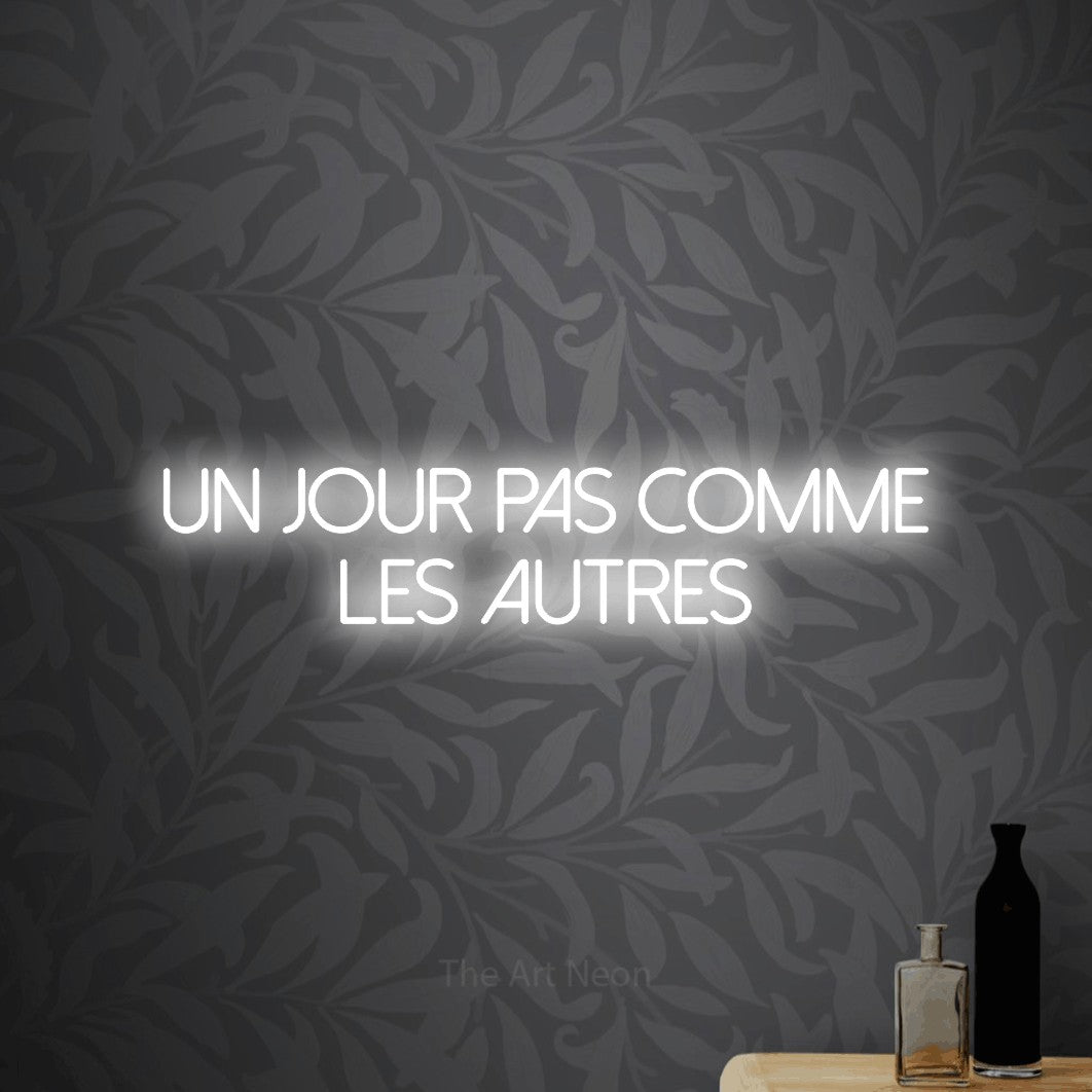 LED neon sign reading “Un Jour Pas Comme Les Autres”, arranged in 2 lines.